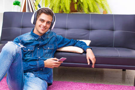young teenager with mobile phone and headphones at home