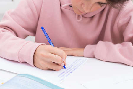 child's hand studying and writing on the school desk or home