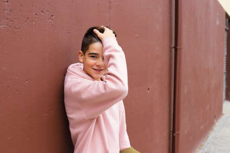 portrait of young preteen on the wall of the street in the cityの写真素材