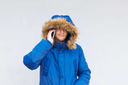 young with mobile phone on the wallの写真素材