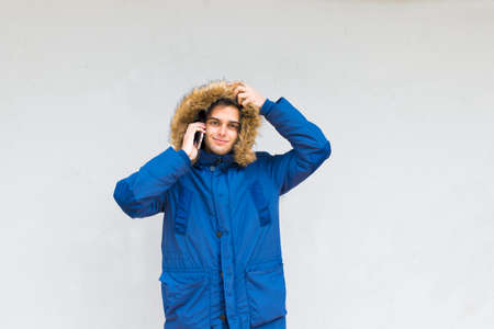 young with mobile phone on the wallの写真素材