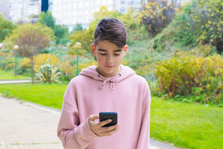 teenager with mobile phone on city streetの写真素材