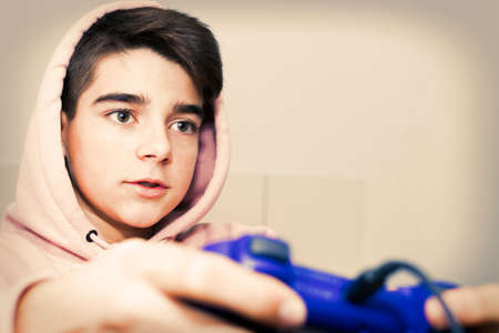 young teenager with game joystick playing at homeの写真素材