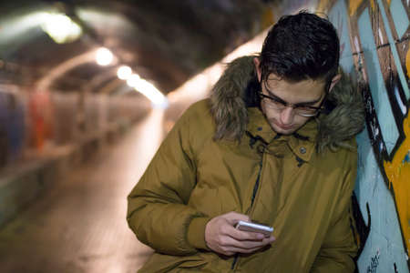 young with mobile phone in the underground of the cityの写真素材