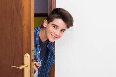 child, teenager or preteen looking out the doorの写真素材