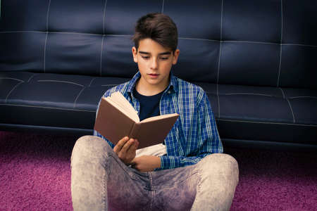 child, teenager or preteen reading a bookの写真素材