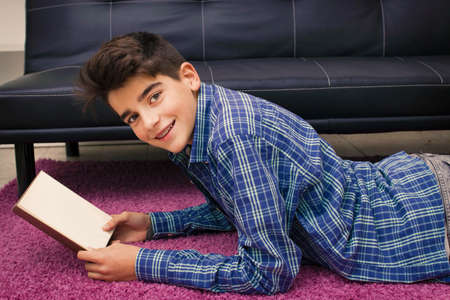 child, teenager or preteen reading or studying at homeの写真素材