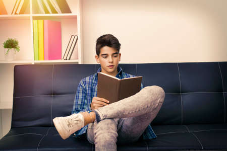 child, teenager or preteen reading or studying at homeの写真素材