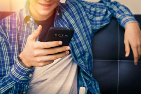 closeup of the young man's hands with the mobile phone