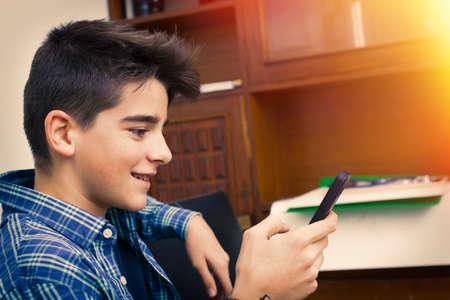 child, teenager or preteen with mobile phone at homeの写真素材