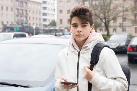 young teenager or preteen on the street with mobile phone