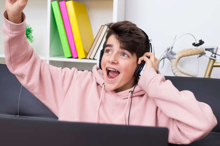 child or teenager with the computer celebrating successの写真素材