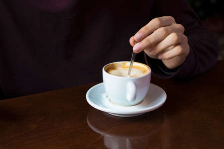 hand with coffee cup in the foregroundの写真素材