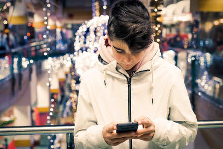 teenage boy or preteen with mobile phone at christmasの写真素材