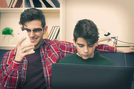 students with the computer and mobile phone at home