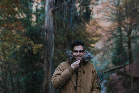 portrait of young man in the forest in autumn or winterの写真素材