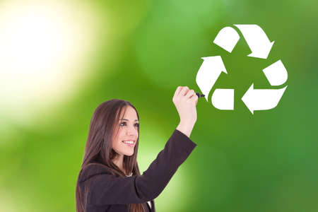 smiling woman drawing the symbol of recyclingの写真素材