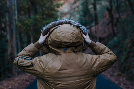 young man back with the hood in the woodsの写真素材