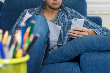 young with mobile phone at home