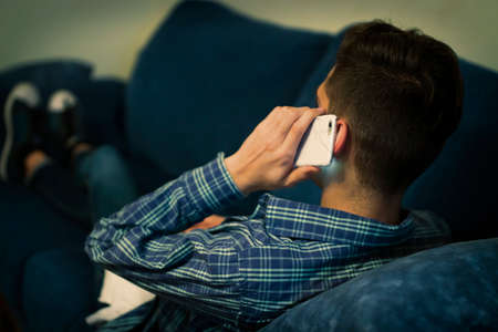 closeup mobile phone in the ear listening and talkingの写真素材