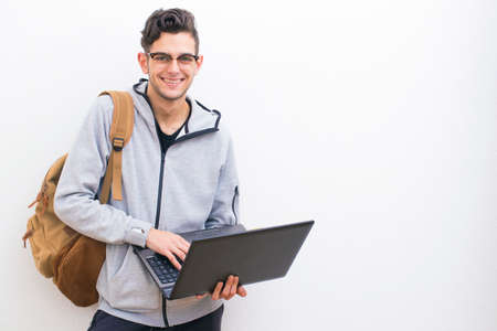 student or young adult with laptop on the white wall with spaceの写真素材