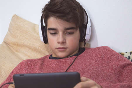 teenager at home with headphones and tabletの写真素材