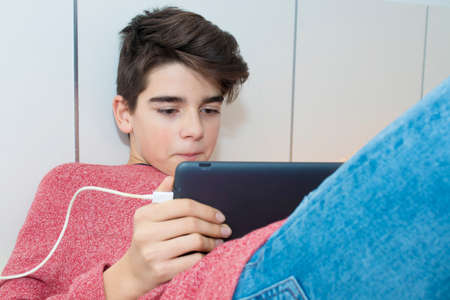 modern young teenager with a tablet at homeの写真素材