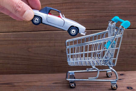hand-in-car in shopping cart, buy carの写真素材