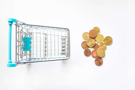 shopping cart with coins on white backgroundの写真素材