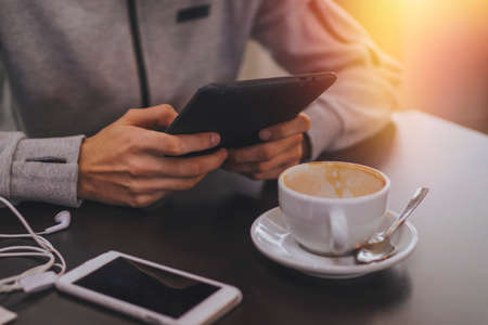 hands with the tablet or the ebook and the coffee mugの写真素材