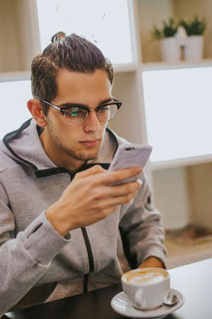 having breakfast or drinking coffee with the mobile phoneの写真素材