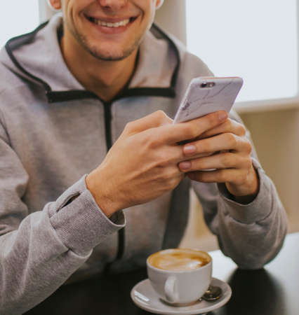 having breakfast or drinking coffee with the mobile phoneの写真素材