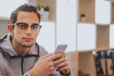 young fashion with mobile phone in the cafeteriaの写真素材
