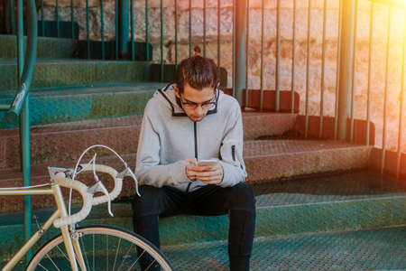 young fashion with mobile phone and bike in city street