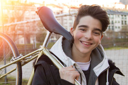young man carrying bicycle outdoorの写真素材