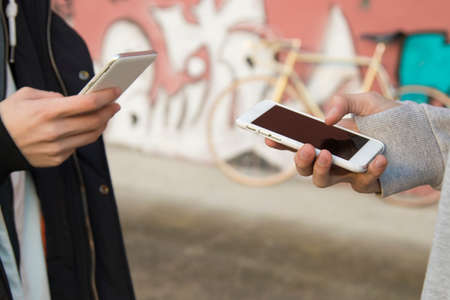 hands of people with mobile phone in the streetの写真素材