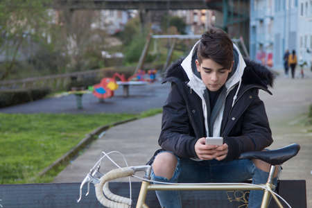 young in town with mobile phone and bikeの写真素材