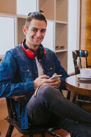 young adult fashion with mobile phone in the cafeteria