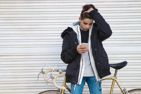 young man with vintage bike on the street wallの写真素材