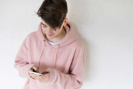 teen with mobile phone on the wall