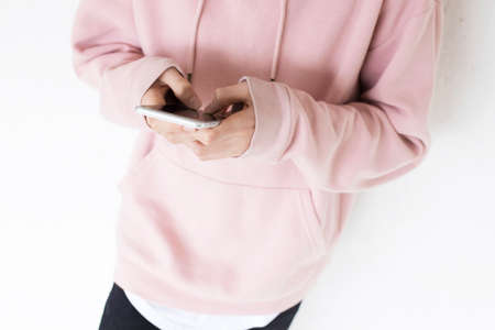 teen with mobile phone on the wallの写真素材