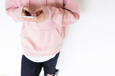 teen with mobile phone on the wall