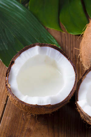Natural coconut on wood with green leaves