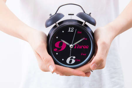 Hands with alarm clock