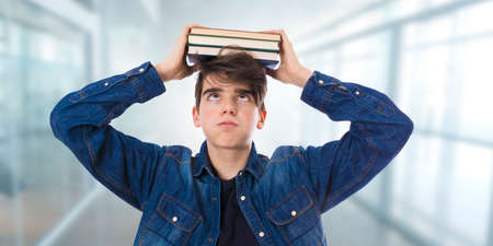 tired or stressed student with books or examsの写真素材