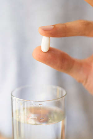 hands with pills or medicine and a glass of water