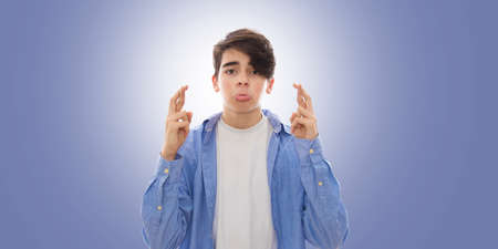 young man with crossed fingers, concept of luckの写真素材