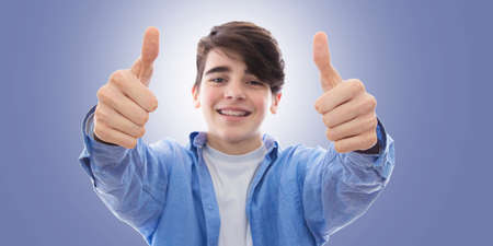 smiling boy with braces and expression of satisfaction and approvalの写真素材