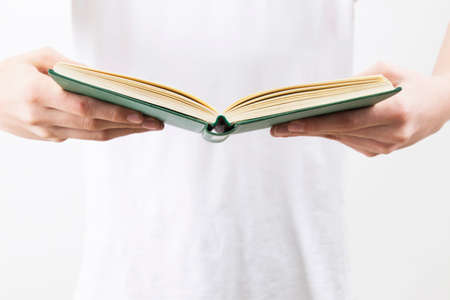 open book in the hands of the young man reading or studying