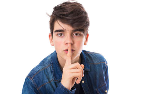 young man with gesture of silence isolated in white backgroundの写真素材